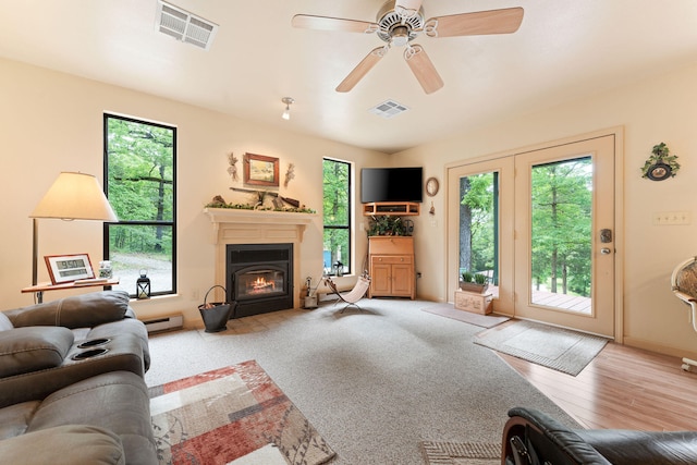 living room with ceiling fan, light hardwood / wood-style floors, and baseboard heating