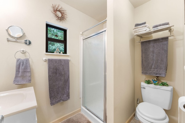 bathroom with vanity, a shower with door, and toilet