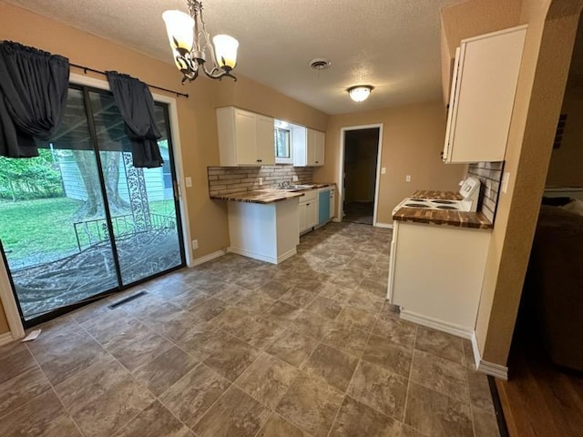 kitchen featuring white cabinets, electric stove, visible vents, and decorative backsplash