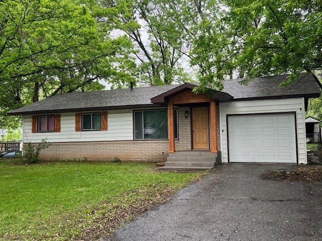 single story home with roof with shingles, a front lawn, brick siding, an attached garage, and aphalt driveway