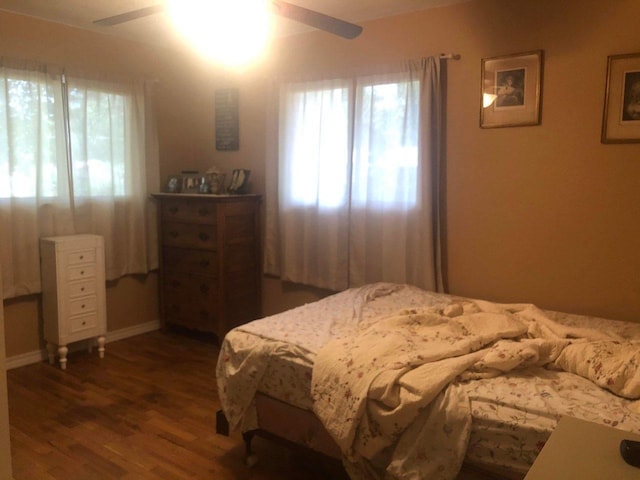 bedroom with dark hardwood / wood-style floors and ceiling fan