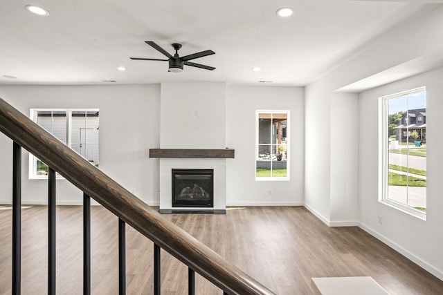 unfurnished living room featuring ceiling fan and wood-type flooring