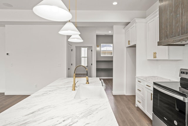 kitchen featuring dark wood-type flooring, electric range, sink, hanging light fixtures, and white cabinetry