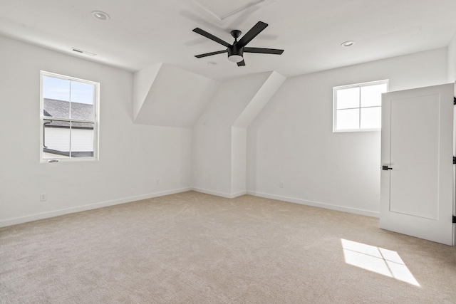 additional living space with light carpet, lofted ceiling, ceiling fan, and a wealth of natural light