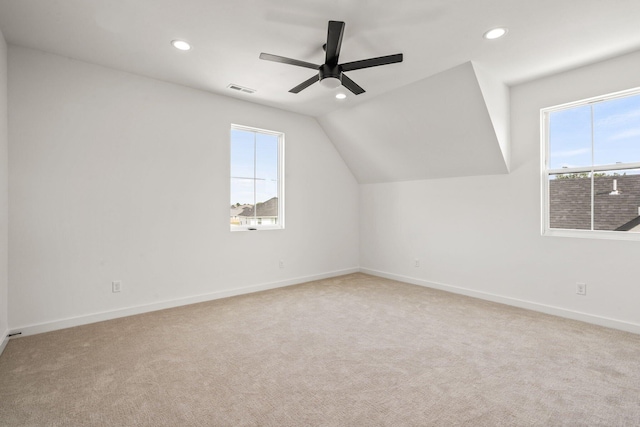 additional living space with light carpet, ceiling fan, and vaulted ceiling