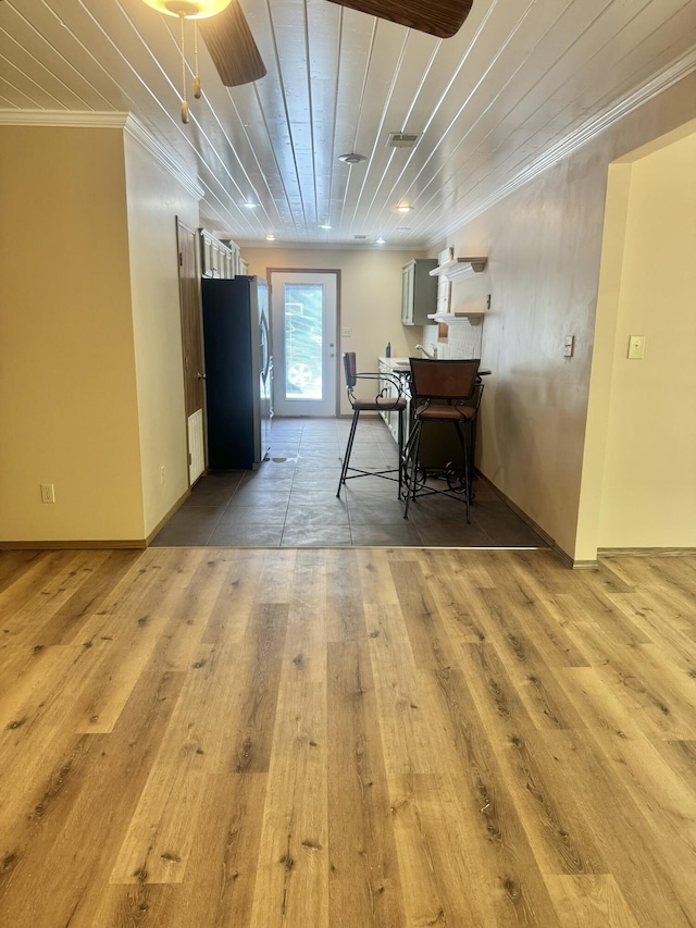 dining area with wooden ceiling, baseboards, ornamental molding, and light wood-type flooring