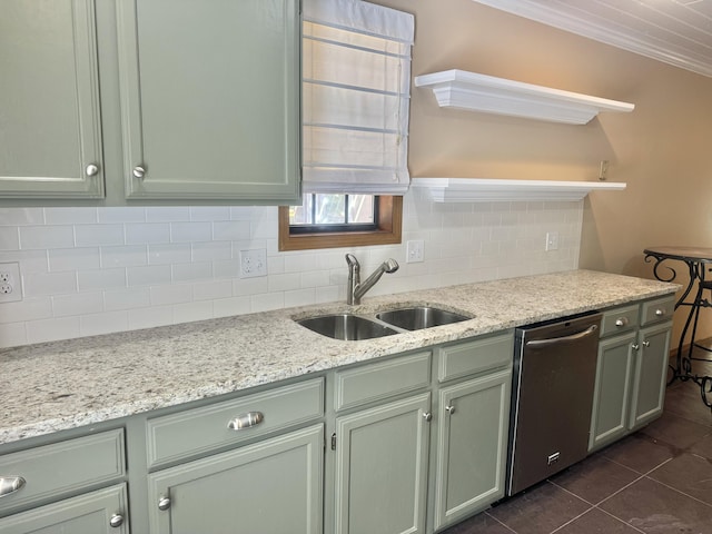 kitchen featuring light stone counters, backsplash, dishwasher, a sink, and dark tile patterned floors