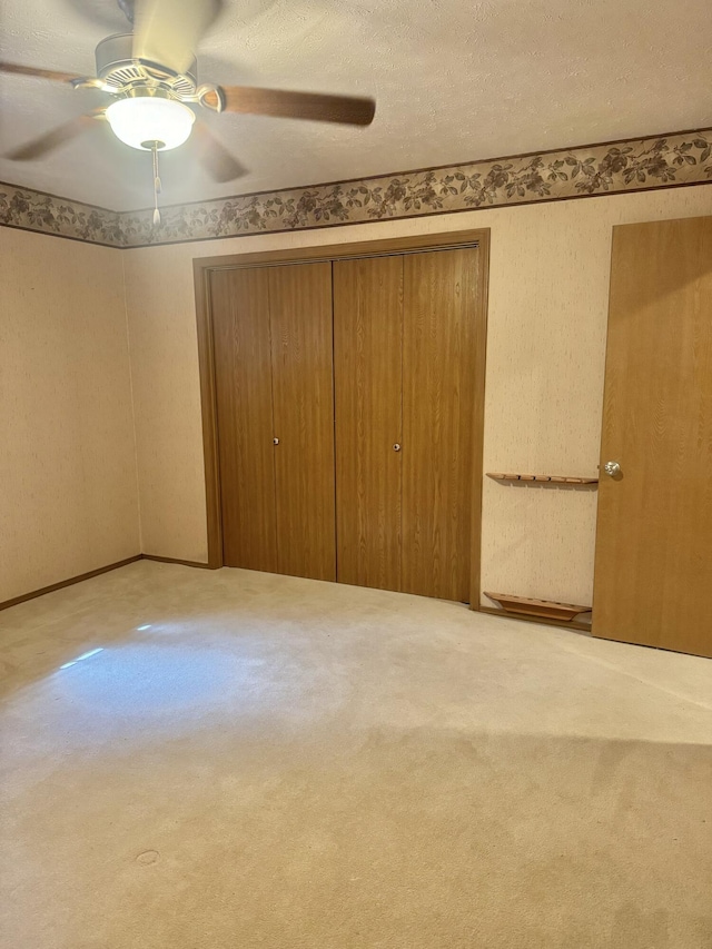 unfurnished bedroom with carpet floors, a closet, and ceiling fan