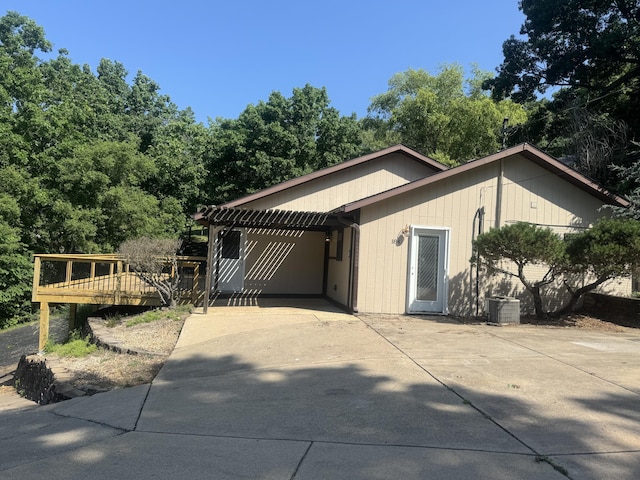 view of side of property with a wooden deck, driveway, and central air condition unit