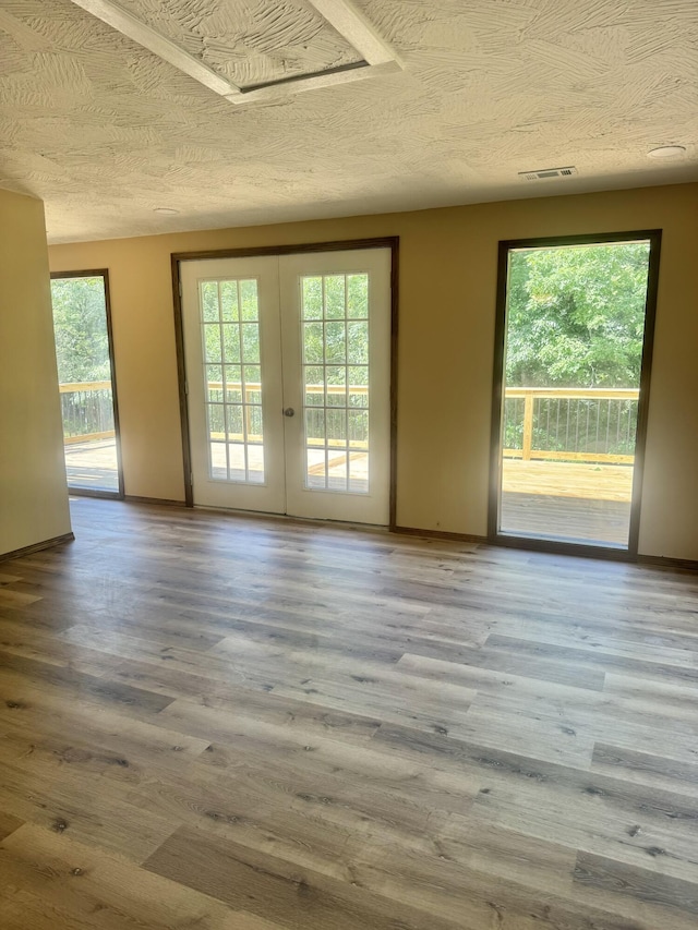 unfurnished room with french doors, wood finished floors, and plenty of natural light