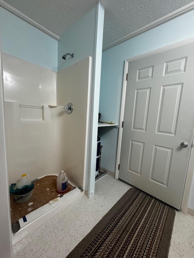 bathroom with a shower and a textured ceiling