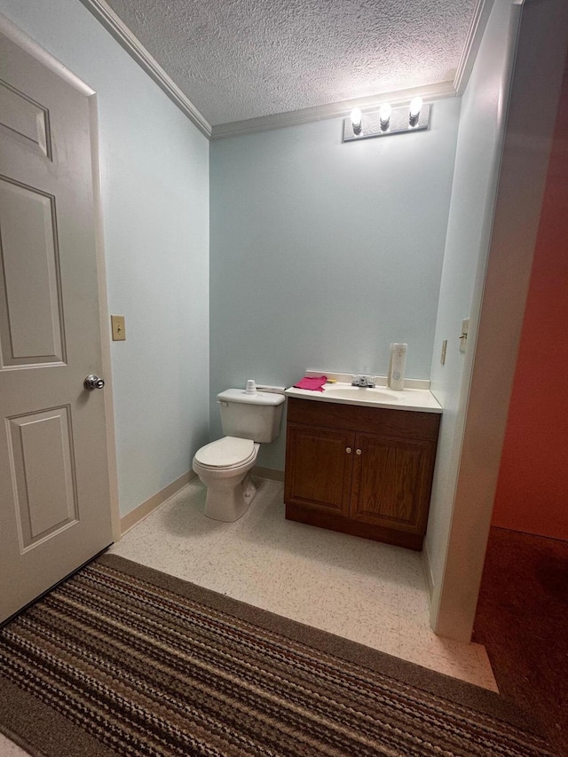 bathroom featuring vanity, crown molding, toilet, and a textured ceiling