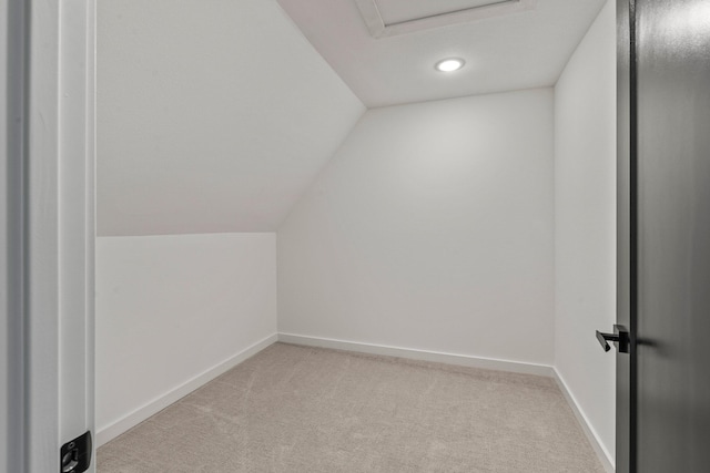 additional living space featuring light colored carpet and vaulted ceiling