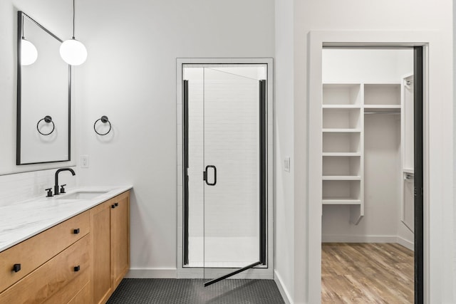 bathroom featuring hardwood / wood-style flooring, vanity, and a shower with shower door