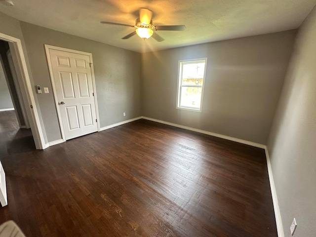 unfurnished room featuring dark hardwood / wood-style flooring and ceiling fan