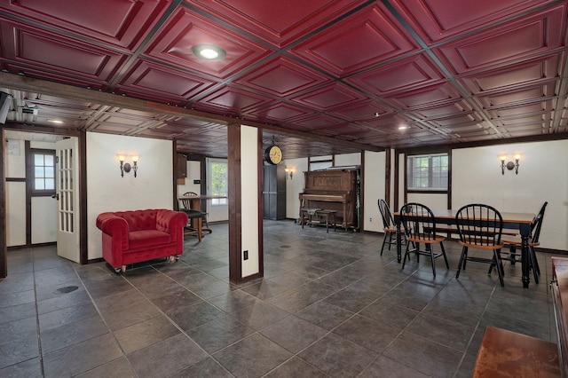 dining area with dark tile patterned flooring and coffered ceiling