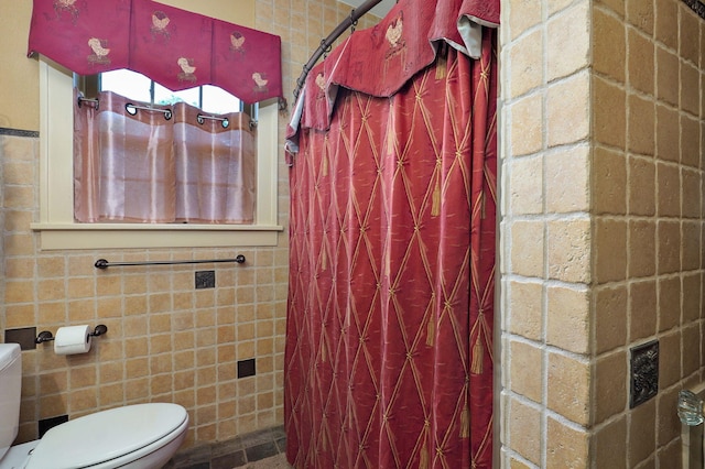 bathroom featuring a shower with curtain, toilet, and tile walls