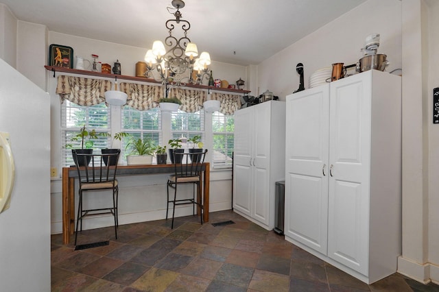 kitchen featuring white refrigerator and a chandelier