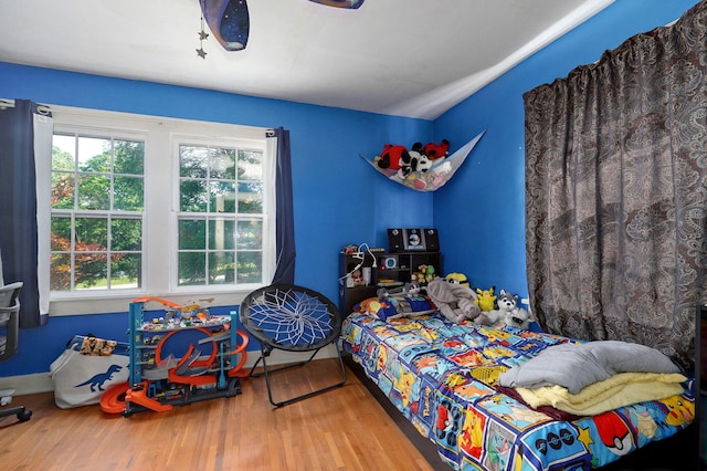 bedroom with ceiling fan and wood-type flooring