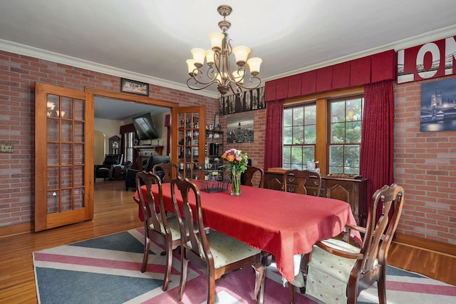 dining area featuring hardwood / wood-style floors, a notable chandelier, and ornamental molding