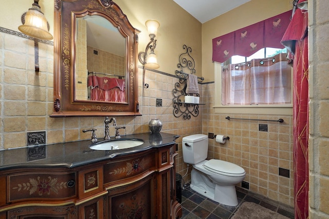 bathroom with vanity, tile walls, and toilet