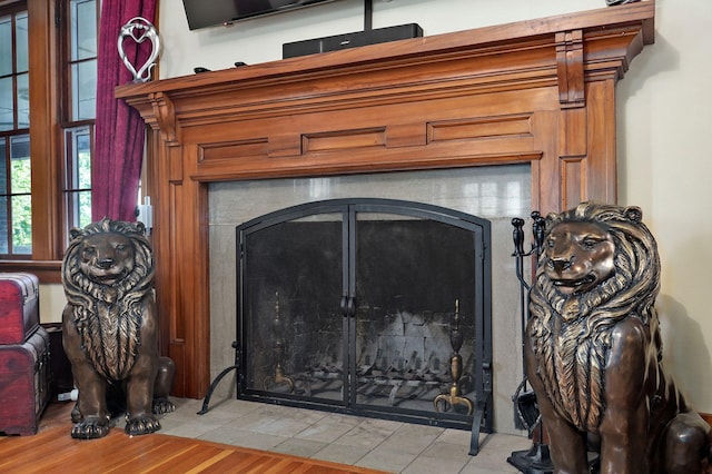 room details with a tiled fireplace and wood-type flooring