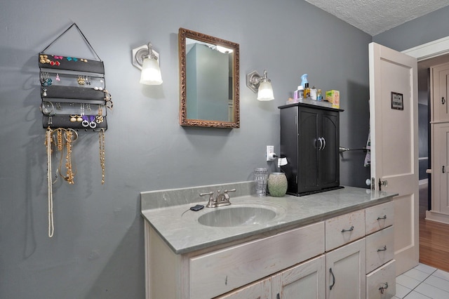 bathroom with vanity, a textured ceiling, and hardwood / wood-style flooring