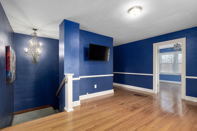 empty room featuring hardwood / wood-style flooring and a notable chandelier