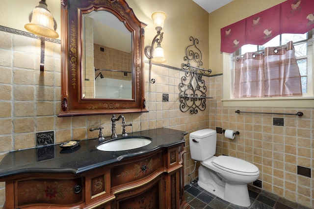 bathroom with tile patterned floors, vanity, toilet, and tile walls