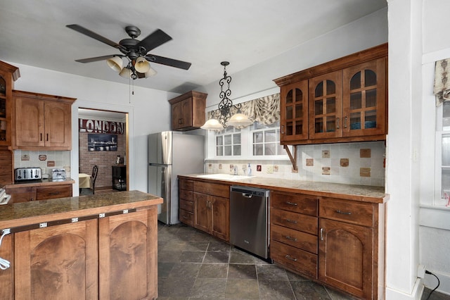 kitchen featuring decorative backsplash, appliances with stainless steel finishes, pendant lighting, and sink