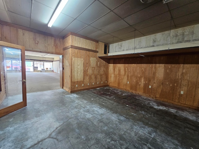 spare room with wooden walls and a paneled ceiling