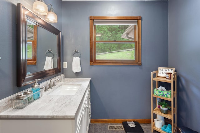 bathroom featuring visible vents, baseboards, and vanity