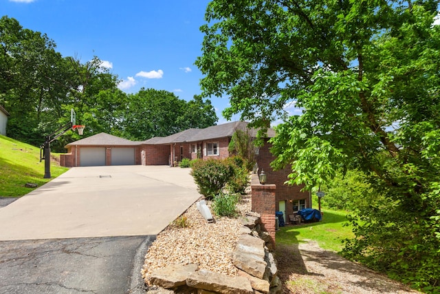 ranch-style home featuring a garage, driveway, a front lawn, and brick siding