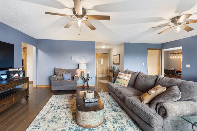 living room featuring ceiling fan, dark wood-type flooring, and a textured ceiling