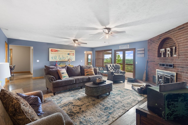 living area with wood finished floors, a ceiling fan, and baseboards