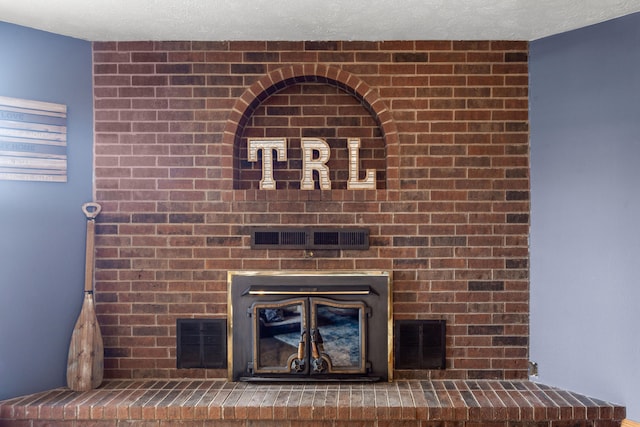 interior details with a large fireplace and a textured ceiling