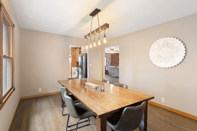 dining space featuring wood-type flooring and ceiling fan