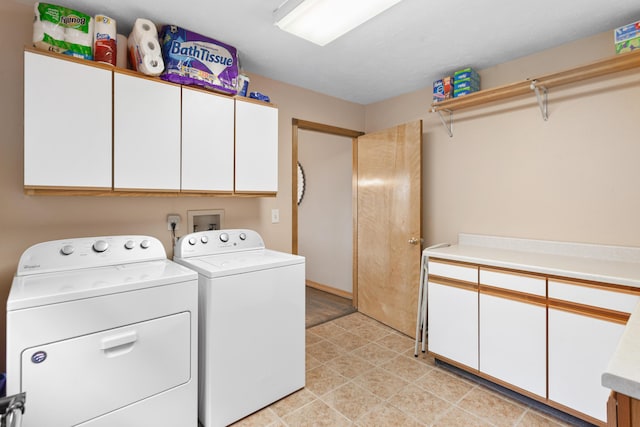 washroom featuring cabinet space and separate washer and dryer