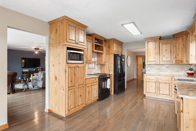 kitchen featuring decorative backsplash, wood finished floors, black appliances, and ceiling fan