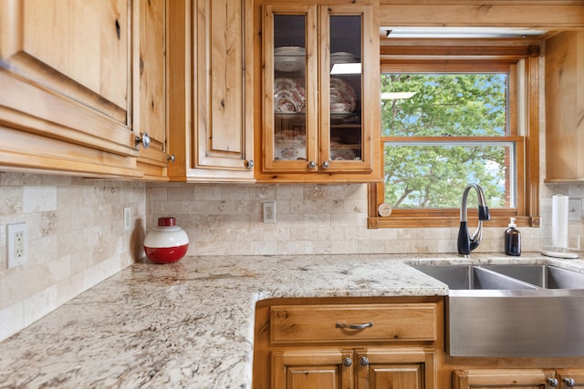 kitchen with backsplash, a wealth of natural light, and glass insert cabinets