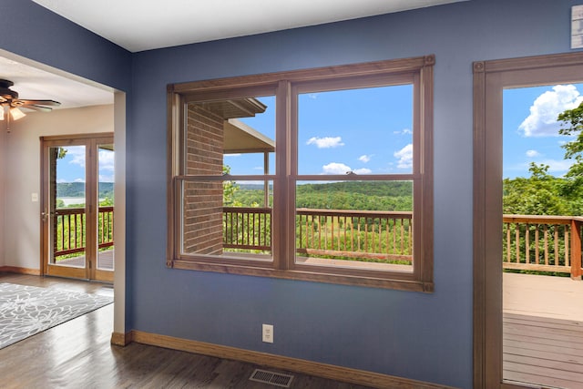 doorway featuring baseboards, wood finished floors, visible vents, and a ceiling fan