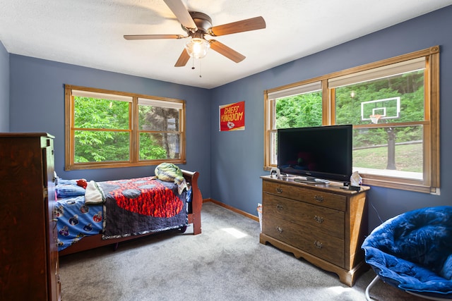 bedroom featuring ceiling fan, light carpet, and multiple windows