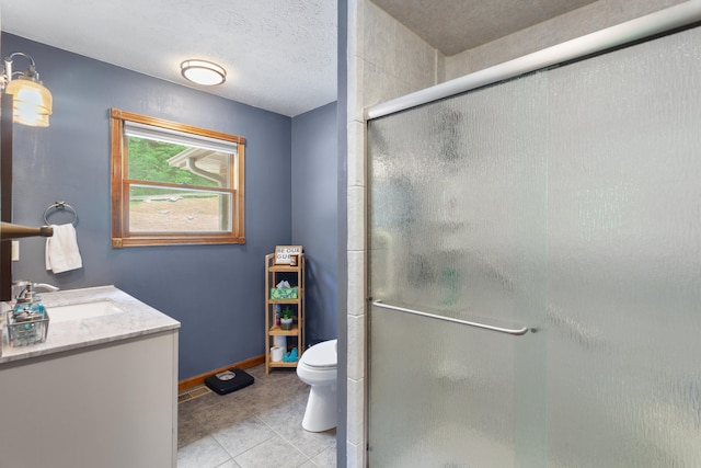 bathroom featuring vanity, tile patterned flooring, a textured ceiling, a shower with shower door, and toilet