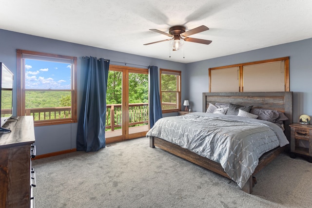 bedroom with access to exterior, multiple windows, ceiling fan, and carpet