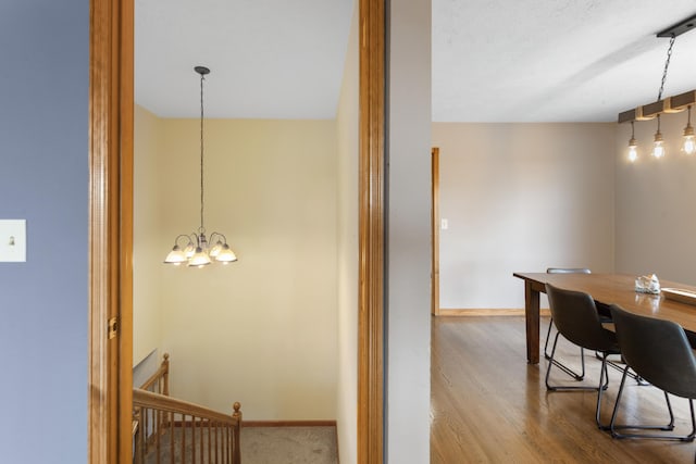 interior space with baseboards, wood finished floors, and a notable chandelier
