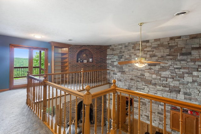 corridor featuring visible vents, carpet, and an upstairs landing