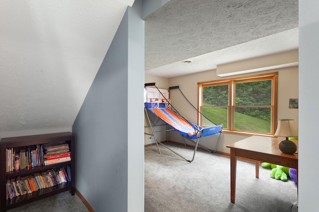 bedroom with carpet floors, lofted ceiling, and a textured ceiling