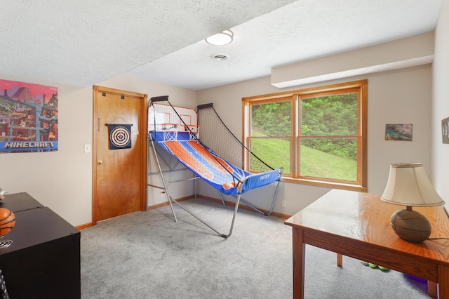 interior space featuring baseboards, a textured ceiling, and visible vents