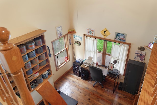office area with a high ceiling and wood finished floors