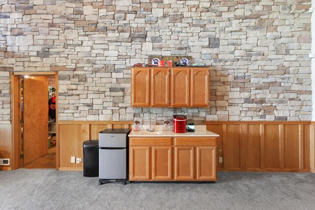 kitchen featuring wainscoting, light countertops, freestanding refrigerator, and light colored carpet